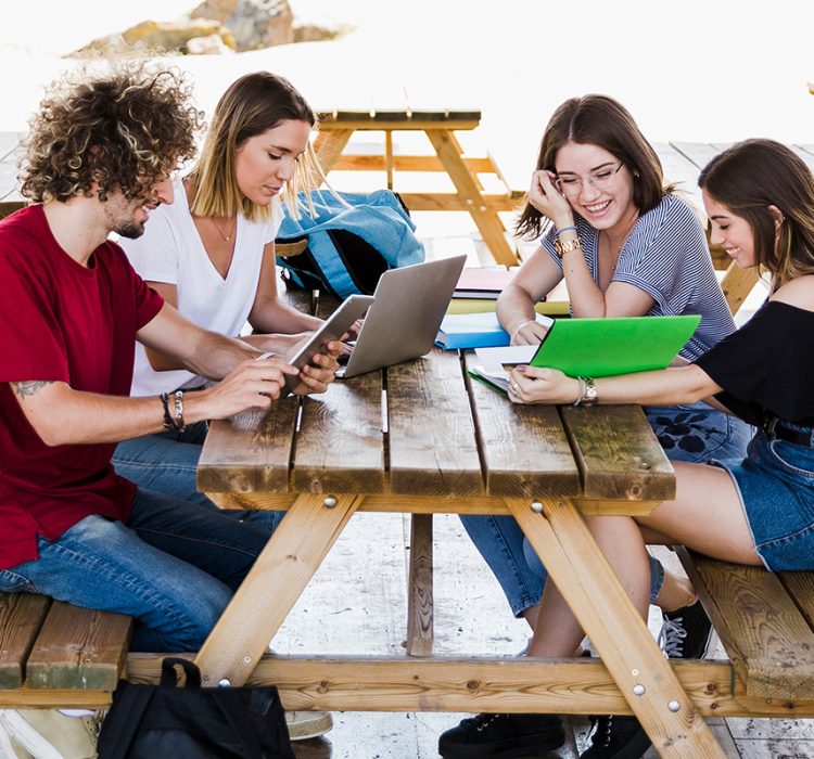 cheerful-friends-studying-table